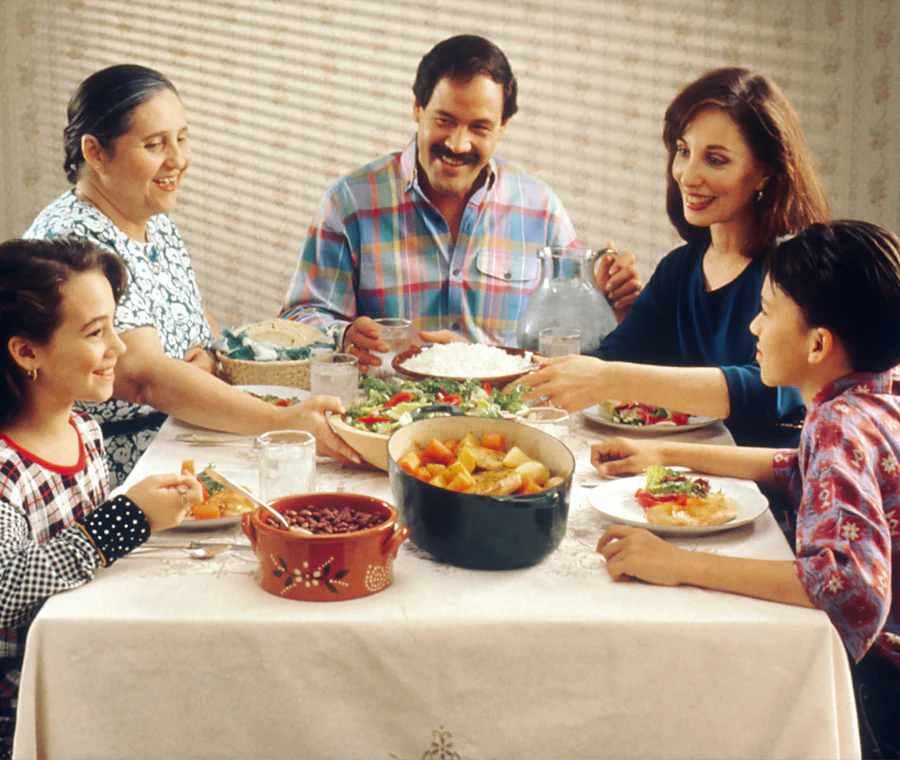 Familia comiendo junta alrededor de una mesa (foto ilustrativa)